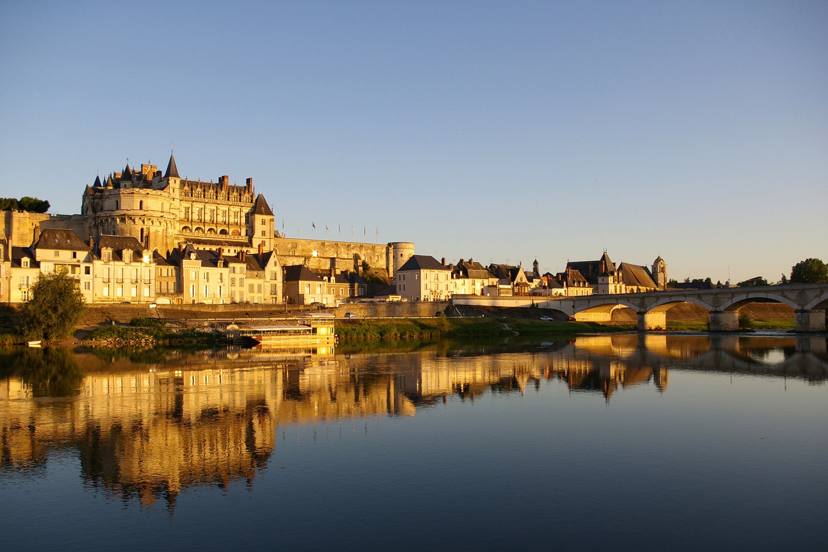 Imagem de imponente castelo na França com vista para um lago espelhado