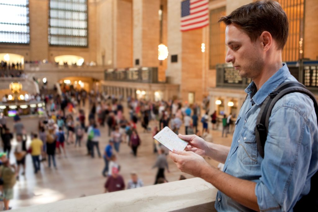 Homem segura o mapa do metrô enquanto caminha pela Grand Central Terminal, em Nova York