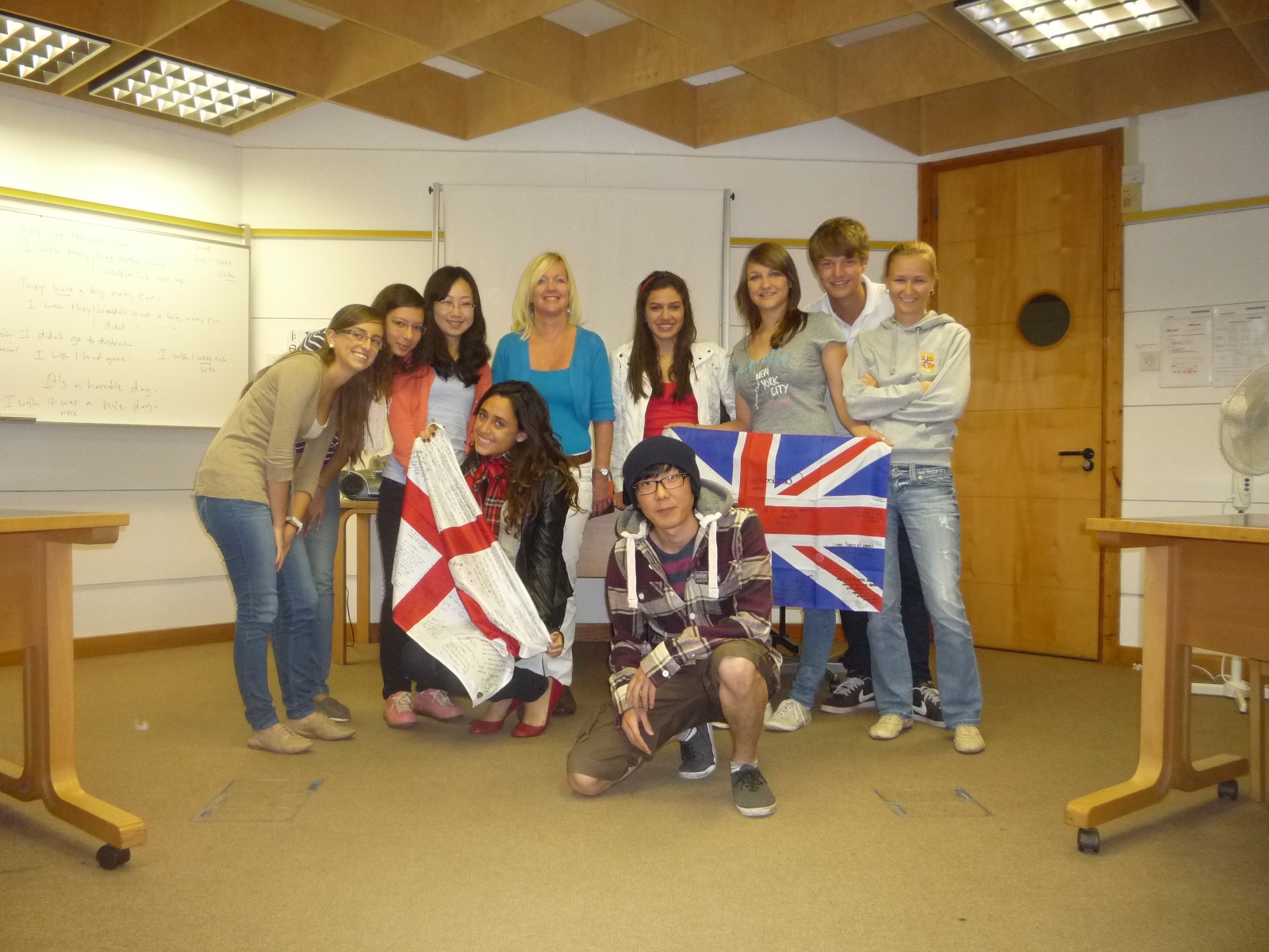 estudantes intercambistas seguram bandeiras da Inglaterra na sala de aula