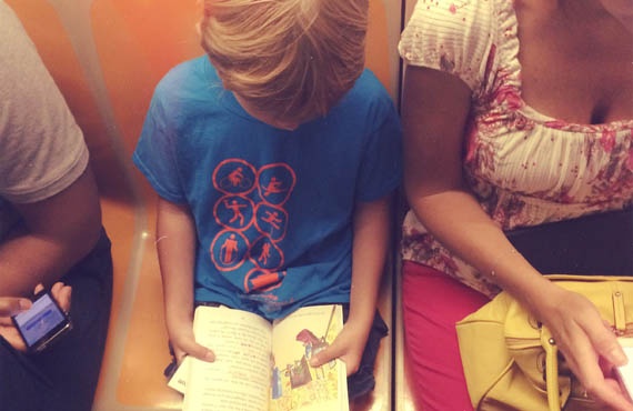 Garotinho lendo em metrô de Nova York