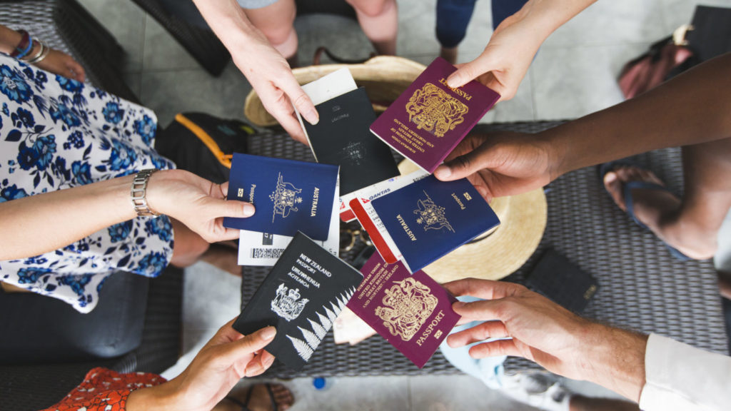 Círculo de amigos mostra passaportes de diferentes nacionalidades