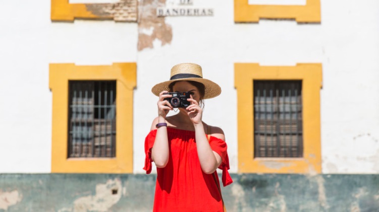 Turista segura uma câmera fotográfica na altura do rosto